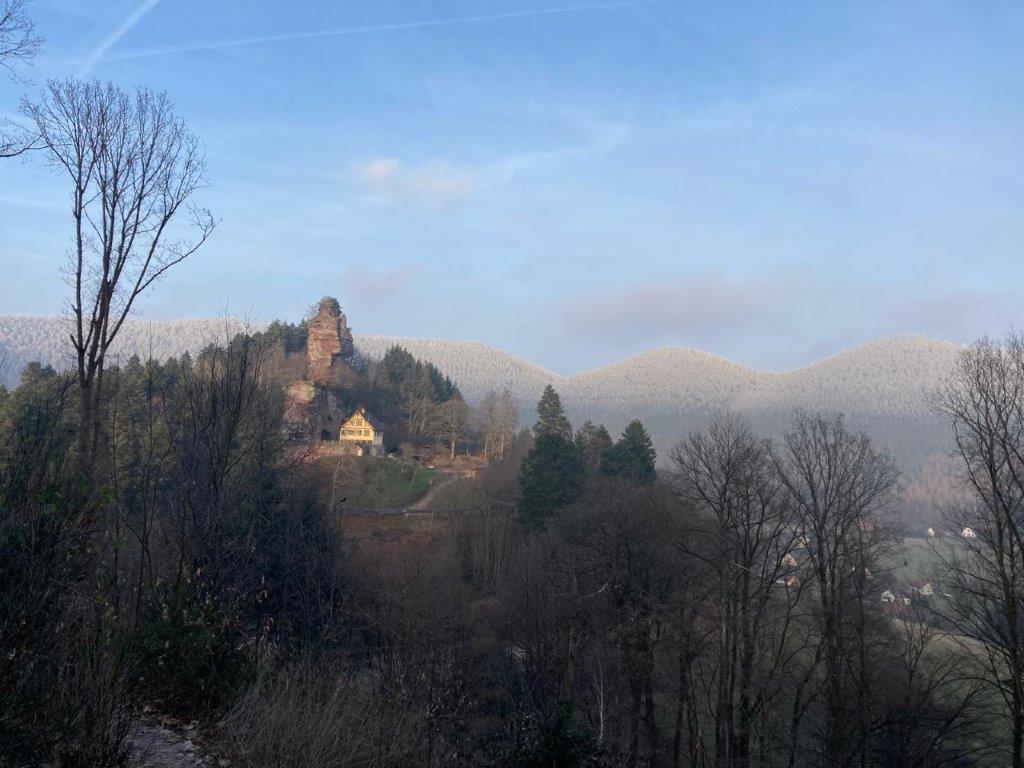 Vallée de Windstein avec le château sur son rocher et les monts enneigés au loin